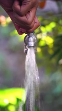 El musluğu açar, su hızla akar. Odaklanma seçildi. Bulanık arkaplan