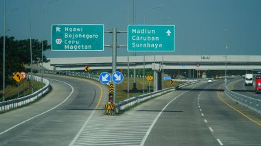 Madiun, Endonezya. 16 Temmuz 2024. Öğlen Trans Java paralı yolu. Madiun, Caruban, Surabaya, Cepu, Ngawi, Bojonegoro şehirleri için işaretler var.