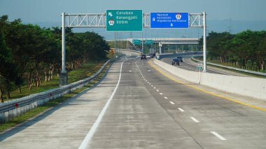 Madiun, Endonezya. 16 Temmuz 2024. Öğlen Trans Java paralı yolu. Caruban, Nganjuk, Kertosono, Mojokerto şehirleri için işaretler var.