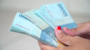 Endonezya 'da 50 bin Rupiah parası tutan ve sayan kadın.