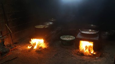 Ahşap ateşli geleneksel mutfak. Şöminenin üzerinde tencere ve tavalar var..