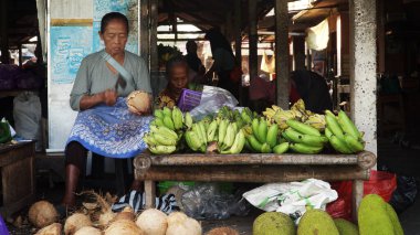 Yogyakarta, Endonezya. 26 Temmuz 2024. Sabah Bantul pazarı. Kadın tüccarlar hindistan cevizi soyuyorlar..