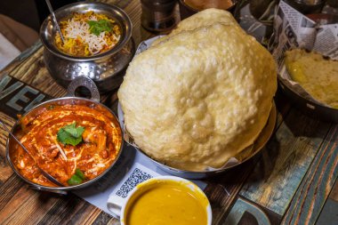 Renkli ve ağız sulandıran Hint yemeği, büyük altın naan ekmeği, zengin kırmızı köri ve egzotik pirinç.