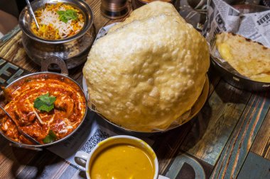 Renkli ve ağız sulandıran Hint yemeği, büyük altın naan ekmeği, zengin kırmızı köri ve egzotik pirinç.