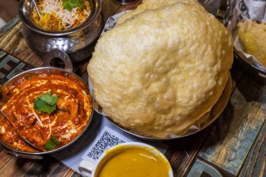 Renkli ve ağız sulandıran Hint yemeği, büyük altın naan ekmeği, zengin kırmızı köri ve egzotik pirinç.