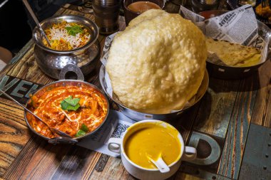 Renkli ve ağız sulandıran Hint yemeği, büyük altın naan ekmeği, zengin kırmızı köri ve egzotik pirinç.