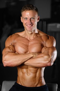 Spor salonunda egzersiz yapan yakışıklı kaslı vücut geliştirmeci erkek