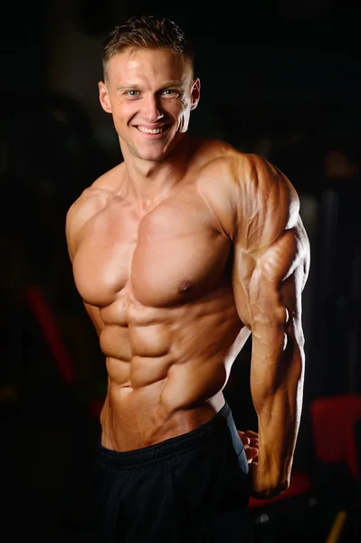 Handsome muscular bodybuilder man doing exercises in gym — Stock Photo, Image