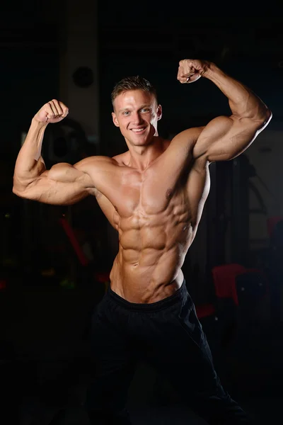 Schöner muskulöser Bodybuilder Mann macht Übungen im Fitnessstudio — Stockfoto