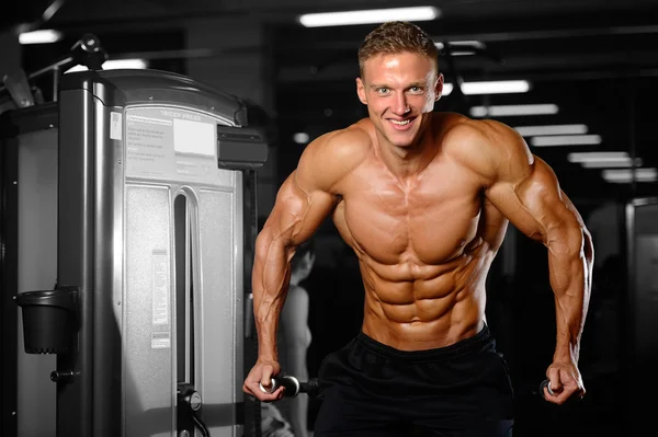 Handsome muscular bodybuilder man doing exercises in gym — Stock Photo, Image