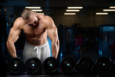 Gy alýþtýrmalarda yapan yakışıklı kaslı vücut geliştirmeci erkek
