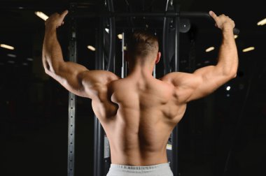 Gy alýþtýrmalarda yapan yakışıklı kaslı vücut geliştirmeci erkek