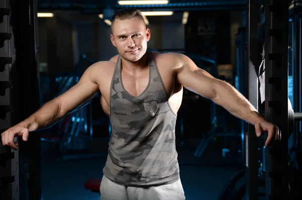 Bonito musculoso fisiculturista homem fazendo exercícios em gy — Fotografia de Stock