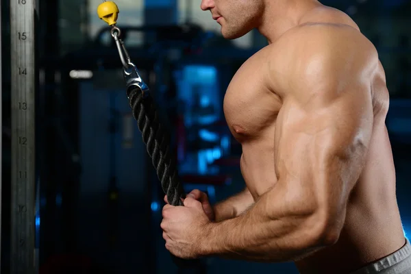 Handsome muscular bodybuilder man doing exercises in gy — Stock Photo, Image