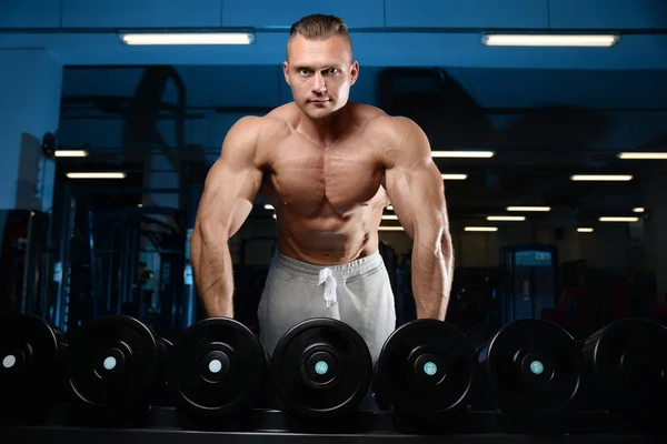 Handsome muscular bodybuilder man doing exercises in gy — Stock Photo, Image