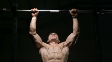 Spor salonundaki adam kaslarını şişiriyor spor salonundaki çıplak bedeninde barfiks egzersizleri yapıyor. Yakışıklı, güçlü atletik erkekler sırt kaslarını çalıştırıyor spor yapıyor ve vücut geliştirme konsepti geliştiriyor.