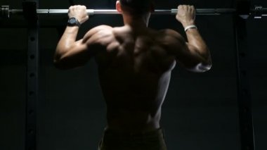 Spor salonundaki adam kaslarını şişiriyor spor salonundaki çıplak bedeninde barfiks egzersizleri yapıyor. Yakışıklı, güçlü atletik erkekler sırt kaslarını çalıştırıyor spor yapıyor ve vücut geliştirme konsepti geliştiriyor.
