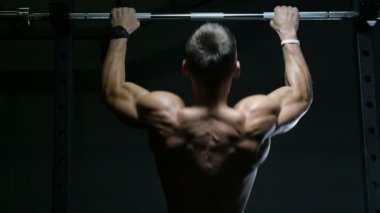 Spor salonundaki adam kaslarını şişiriyor spor salonundaki çıplak bedeninde barfiks egzersizleri yapıyor. Yakışıklı, güçlü atletik erkekler sırt kaslarını çalıştırıyor spor yapıyor ve vücut geliştirme konsepti geliştiriyor.