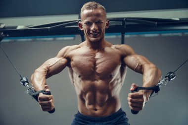 Vücut geliştiren yakışıklı, güçlü, atletik yakışıklı, göğüs kaslarını şişiren, vücut geliştiren, sağlıklı konsept geliştiren, vücut geliştiren, kas geliştiren, vücut geliştiren, göğüs egzersizleri yapan, çıplak gövde egzersizleri yapan adam.