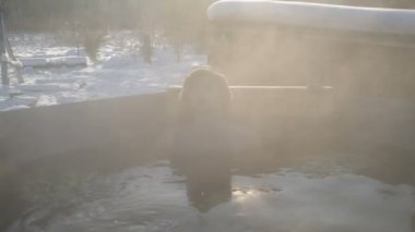 Yakışıklı bir adam, karlı bir kışta sıcak suda banyoda buharla yıkandı. Spor, sağlık ve sertleşme kavramı  