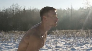 Fitness adamı kışın açık havada kaslarını kettlebell ile şişiriyor. Sağlık, spor ve sertleştirme konsepti