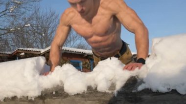 Spor salonundaki adam çıplak bir gövdeyle spor yapıyor. Kışın açık havada şınav. Spor, sağlık ve sertleşme kavramı  