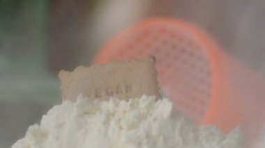 Protein tozu ve ölçüm kepçesi kavanozun üzerinde ve sallanan şişe arka planında. Vücut geliştirme, fitness ve spor salonu yaşam tarzı. Spor, sağlık ve beslenme konsepti