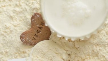 Süt, vejetaryen kurabiye, protein tozu ve ölçü kepçesinin üzerine dökülür. Üst Manzara. Yukarıdan bak. Vücut geliştirme, fitness ve spor salonu yaşam tarzı. Spor, sağlık ve beslenme konsepti