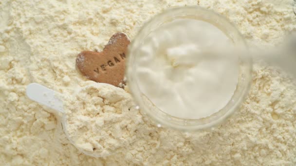 Γάλα Χύνεται Ένα Ποτήρι Πάνω Από Vegan Μπισκότο Και Σκόνη — Αρχείο Βίντεο