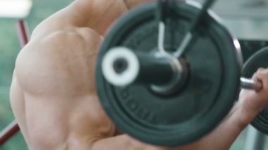 Beyaz tenli atletik adam kaslarını şişiriyor. Güçlü vücut geliştirici, karın kasları, trisepsleri, göğsü ve omuzları var. Fitness ve vücut geliştirme konsepti