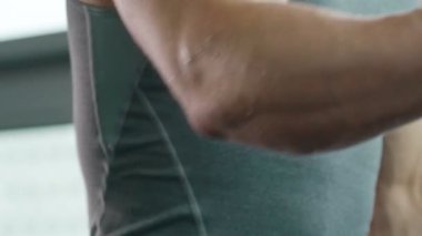 Spor giyimli beyaz bir genç spor salonunda koşu bandında koşuyor. Fitness, vücut geliştirme ve yağ yakma konsepti 