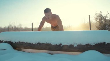 Spor salonundaki adam çıplak bir gövdeyle spor yapıyor. Kışın açık havada şınav. Spor, sağlık ve sertleşme kavramı  