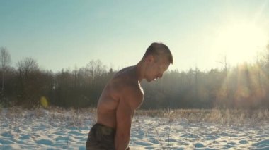 Fitness adamı kışın açık havada kaslarını kettlebell ile şişiriyor. Sağlık, spor ve sertleştirme konsepti