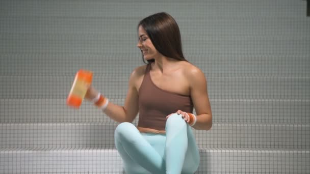 Fitness Frau Trinkt Beim Training Fitnessstudio Wasser Aus Einem Orangefarbenen — Stockvideo