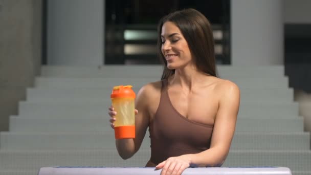 Fitness Vrouw Die Water Drinkt Uit Een Oranje Roze Shaker — Stockvideo