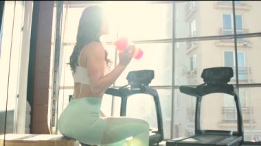 Spor salonunda spor salonunda spor salonundaki turuncu ve pembe karıştırıcıdan su içen kadın. Egzersiz yapan beyaz bir kız. Fitness, vücut geliştirme ve sağlık hizmeti kavramı. 