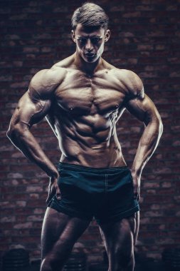 Vücut geliştirici yakışıklı güçlü atletik sert adam karın kaslarını şişiriyor vücut geliştirme egzersizi sağlıklı konsept tasarımı - kaslı fitness adamları spor salonunda çıplak gövde egzersizleri yapıyor