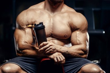 Vahşi seksi vücut geliştirme sporcusu kaslarını çalıştıran vücut geliştirme konsepti geliştiren sporcu. Spor salonunda çıplak vücut geliştirme egzersizleri yapan kaslı yakışıklı erkekler.