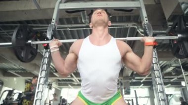 İyi görünümlü bir adam, dışarıda pencerenin önünde antreman yapmadan önce spor salonunda bileklerini ve kaslarını ısıtıyor. Vücut geliştirme, fitness ve sağlık hizmeti kavramı. 