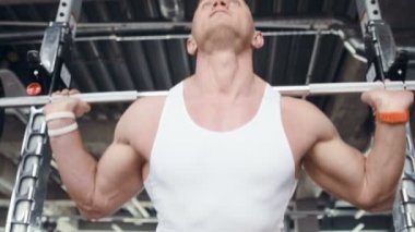 İyi görünümlü bir adam, dışarıda pencerenin önünde antreman yapmadan önce spor salonunda bileklerini ve kaslarını ısıtıyor. Vücut geliştirme, fitness ve sağlık hizmeti kavramı. 