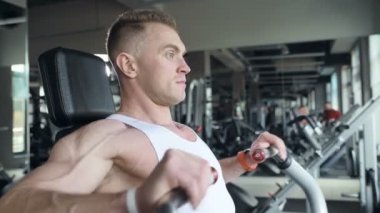 İyi görünümlü bir adam, dışarıda pencerenin önünde antreman yapmadan önce spor salonunda bileklerini ve kaslarını ısıtıyor. Vücut geliştirme, fitness ve sağlık hizmeti kavramı. 
