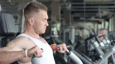İyi görünümlü bir adam, dışarıda pencerenin önünde antreman yapmadan önce spor salonunda bileklerini ve kaslarını ısıtıyor. Vücut geliştirme, fitness ve sağlık hizmeti kavramı. 