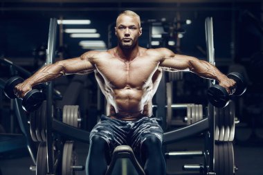 Formda adam eğitimi spor salonunda kasları temizler. Bağırma egzersizi yapıyorum. Antrenmanda kasları kapat. Vücut geliştirme, fitness ve sağlık hizmeti kavramı.