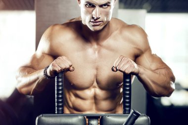 Spor salonunda karın kaslarını çalıştıran formda bir adam. Karın egzersizi şişiriyorum. Antrenmanda kasları kapat. Vücut geliştirme, fitness ve sağlık hizmeti kavramı.