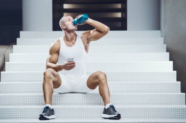 Spor salonunda sallanan formda bir adam. Vücut geliştirme ve sağlıklı yaşam tarzı konsepti. Spor besin takviyeli kas geliştirici spor salonunda çıplak gövde kavanozu.