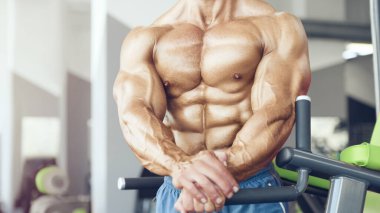 Spor salonunda karın kaslarını çalıştıran formda bir adam. Karın egzersizi şişiriyorum. Antrenmanda kasları kapat. Vücut geliştirme, fitness ve sağlık hizmeti kavramı.