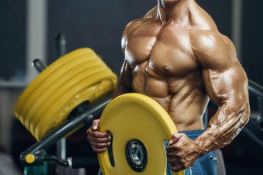 Spor salonunda karın kaslarını çalıştıran formda bir adam. Karın egzersizi şişiriyorum. Antrenmanda kasları kapat. Vücut geliştirme, fitness ve sağlık hizmeti kavramı.