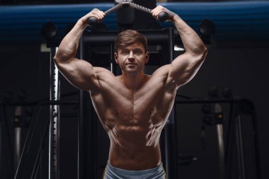 Kafkas atletik adam triseps kaslarını çalıştırıyor. Güçlü vücut geliştirici, karın kasları mükemmel. Spor ve spor konsepti