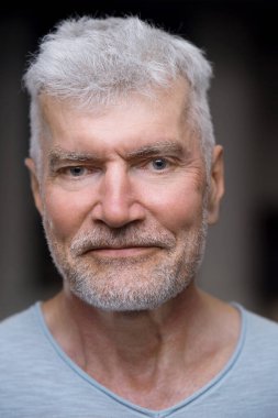 Beyaz tişörtlü, yakışıklı, gri saçlı son sınıf öğrencisinin portresi. Spor ve sağlık konsepti