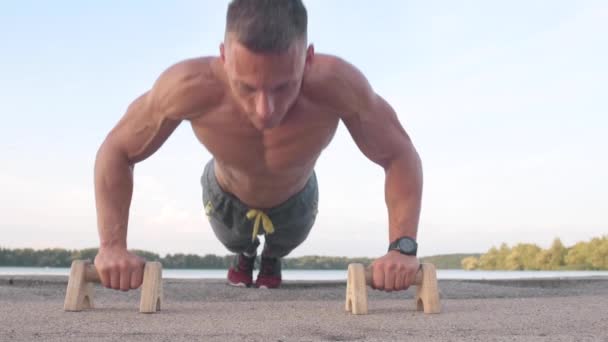 筋肉運動の若い男が平行棒で膿をやっています スポーツとヘルスケアの概念 — ストック動画